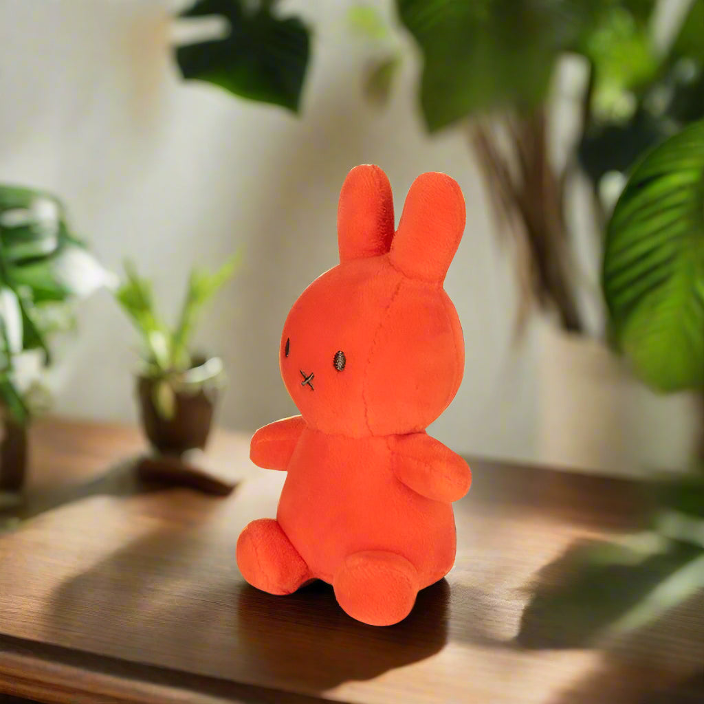 Bright orange plush stuffed toy rabbit angled to the left