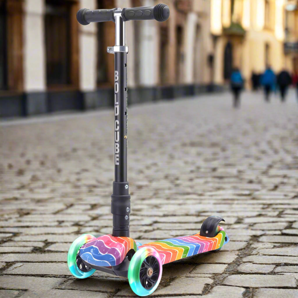 Children's three wheeled scooter with rainbow-coloured design on tread and wheels and 'Bold Cube' written down the vertical bar