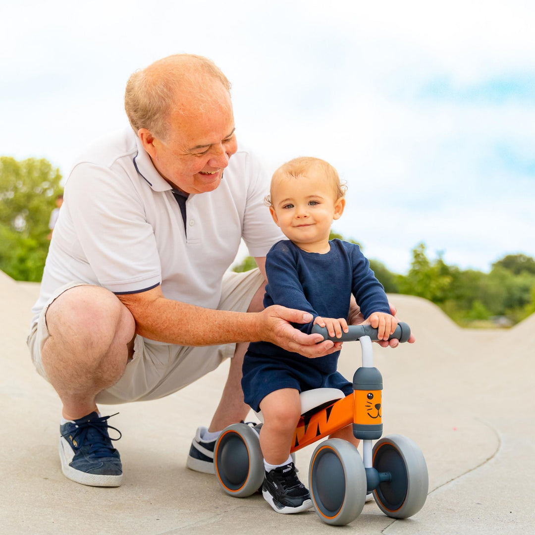 Man and child with a balance bike outdoors on a sunny day