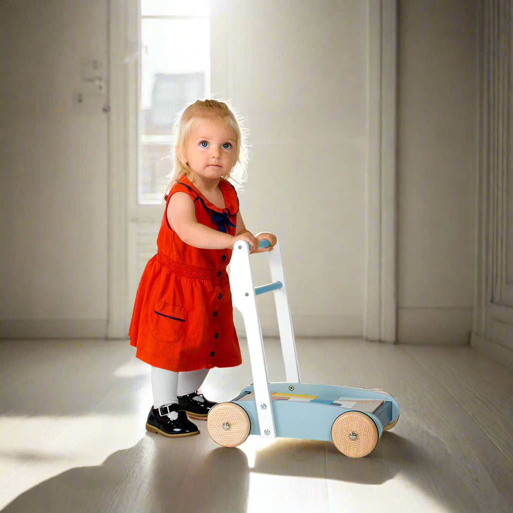 Side on image of young child pushing baby walker