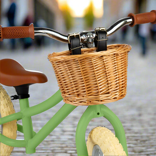 Close up of brown wicker saddle with leather straps attaching it to handlebars