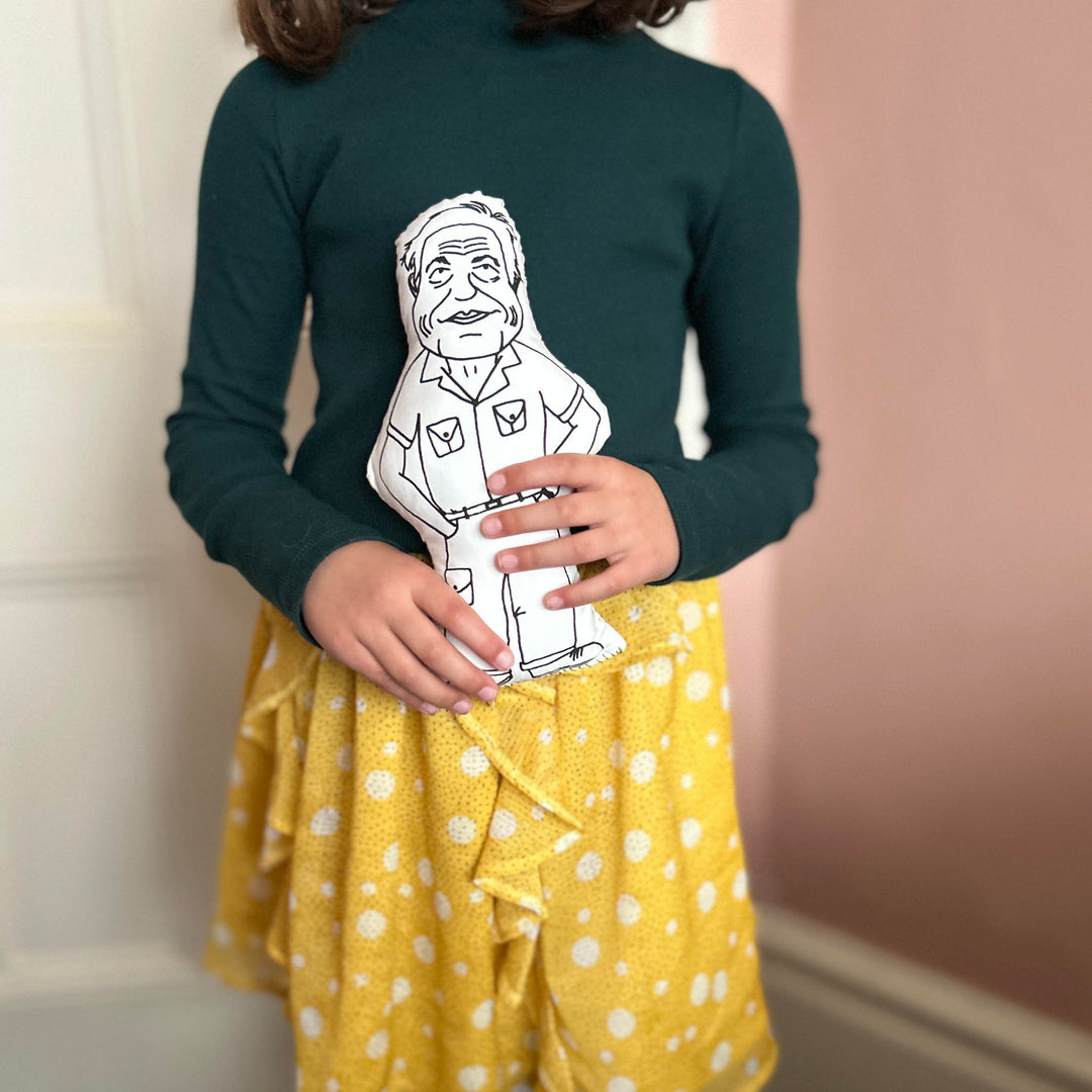 A chil holding the screen printed doll cushion of David Attenborough