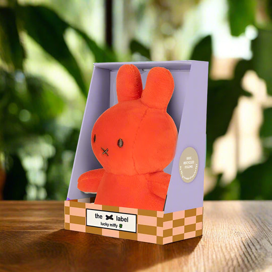 Bright orange stuffed toy rabbit in purple gift box