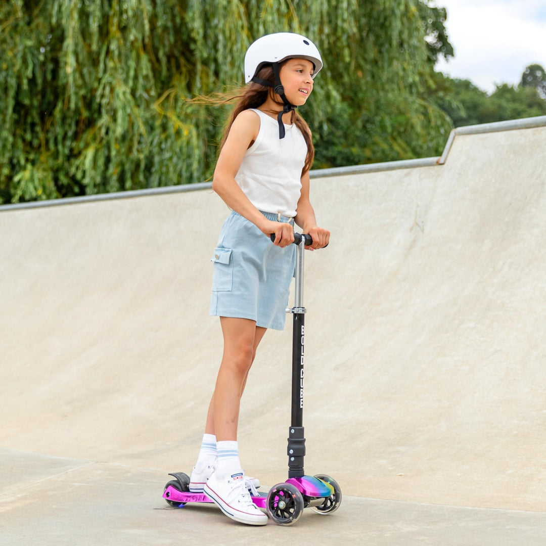 Young girl with a scooter at a skate park