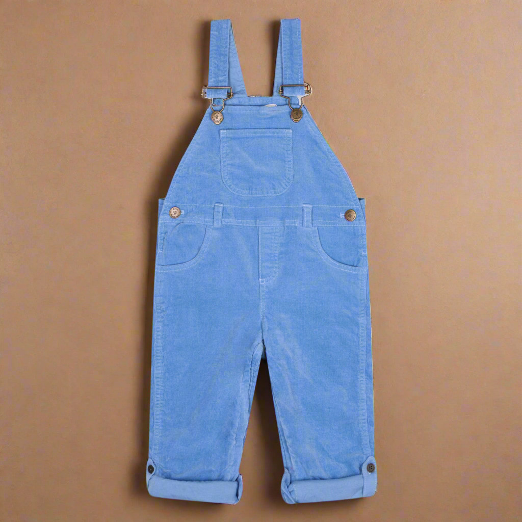 Corduroy dungarees in a mid-pale blue in the likeness of forget-me-not flowers, with two side pockets and one central pocket on the chest with brass buttons