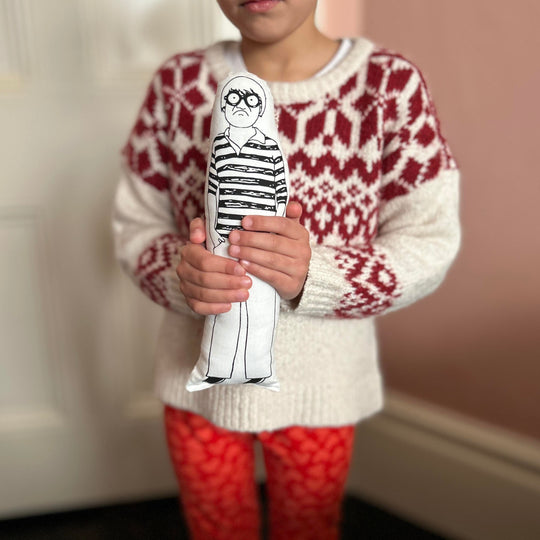 A child holding screen printed doll cushion of David Hockney