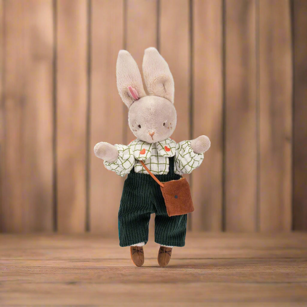 Stuffed toy rabbit wearing navy corduroy dungarees and a white checked shirt with a satchel bag and its arms raised