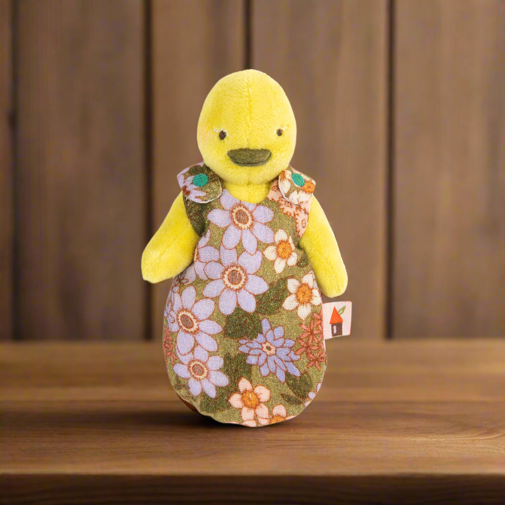 Plush toy yellow duck wearing a retro 70s-style floral sleepsack