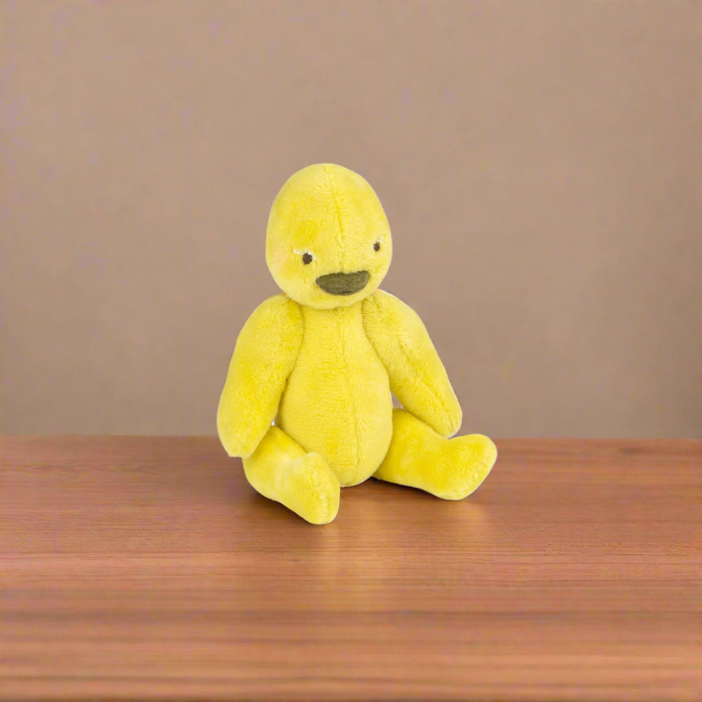 Yellow plush toy duck sitting without the sleepsack