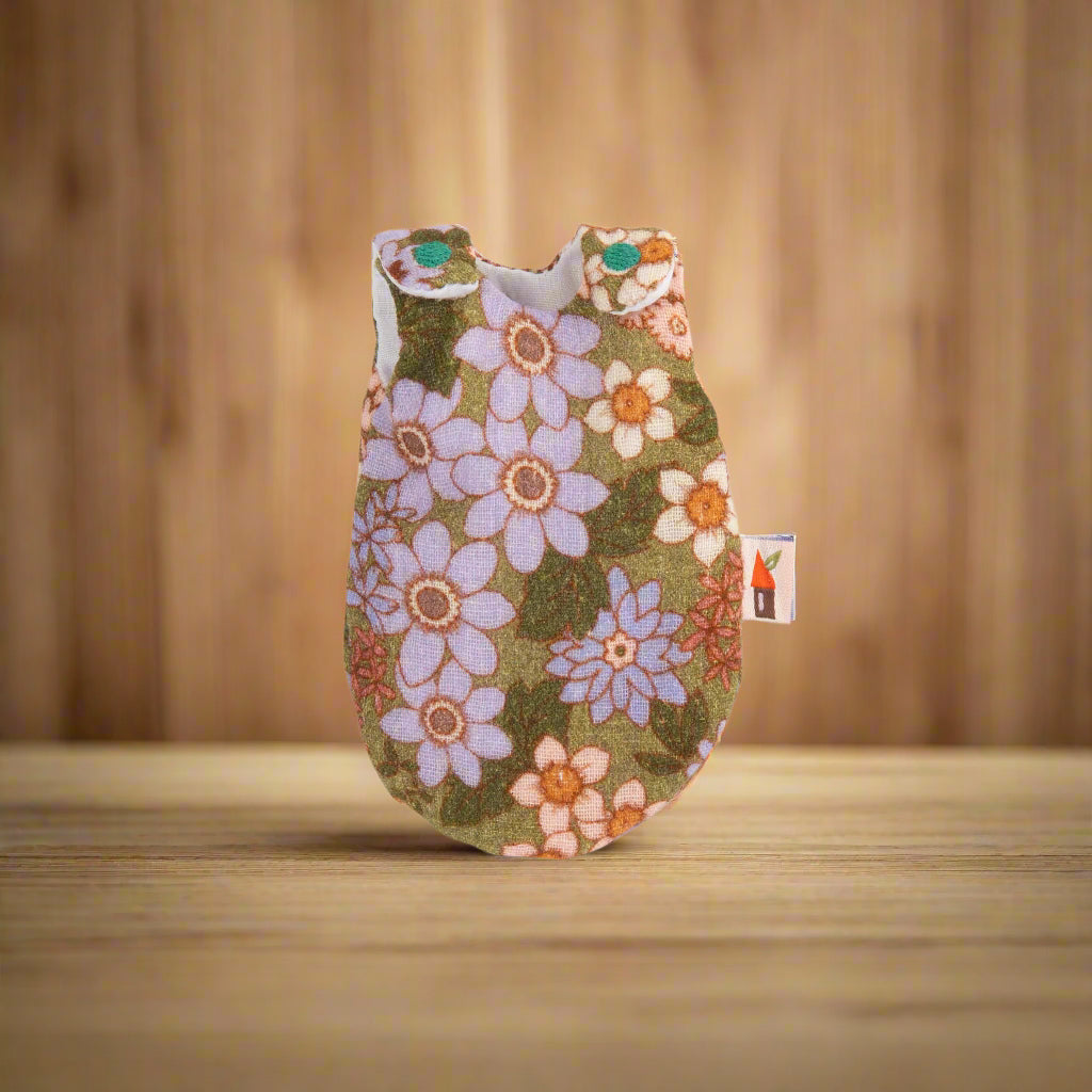 Retro 70s-style floral patterned sleepsack with embroidered turquoise circles on shoulder fastenings