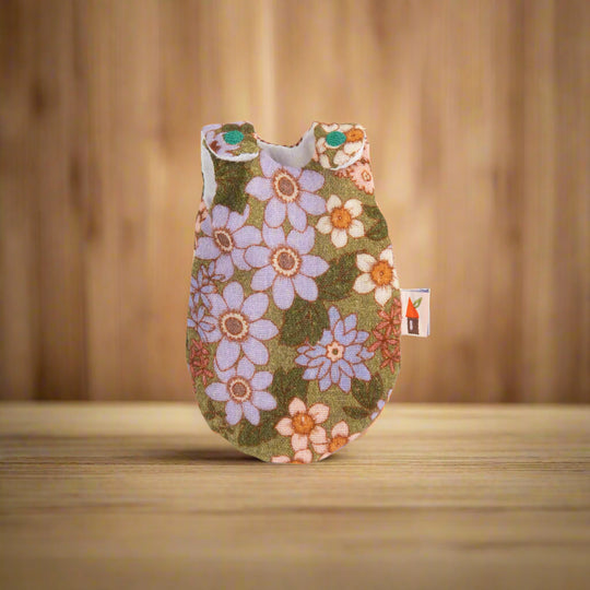 Retro 70s-style floral patterned sleepsack with embroidered turquoise circles on shoulder fastenings