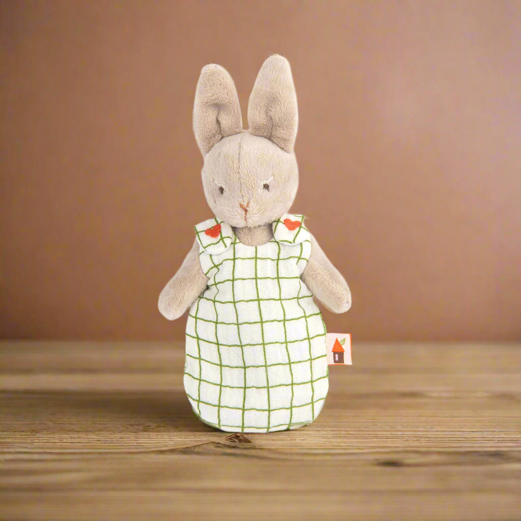 Stuffed rabbit toy wearing a white sleepsack with green checkered pattern and embroidered red hearts on the shoulders