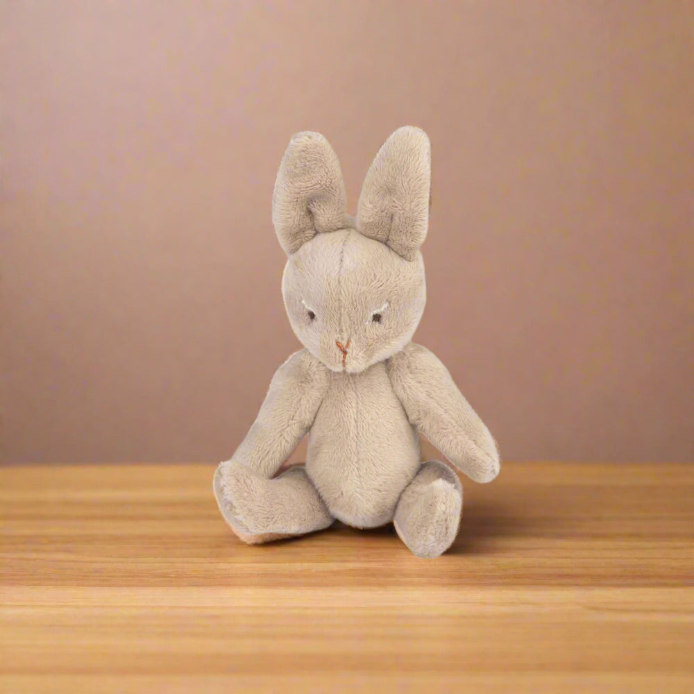 Stuffed rabbit toy sitting down without the sleepsack on