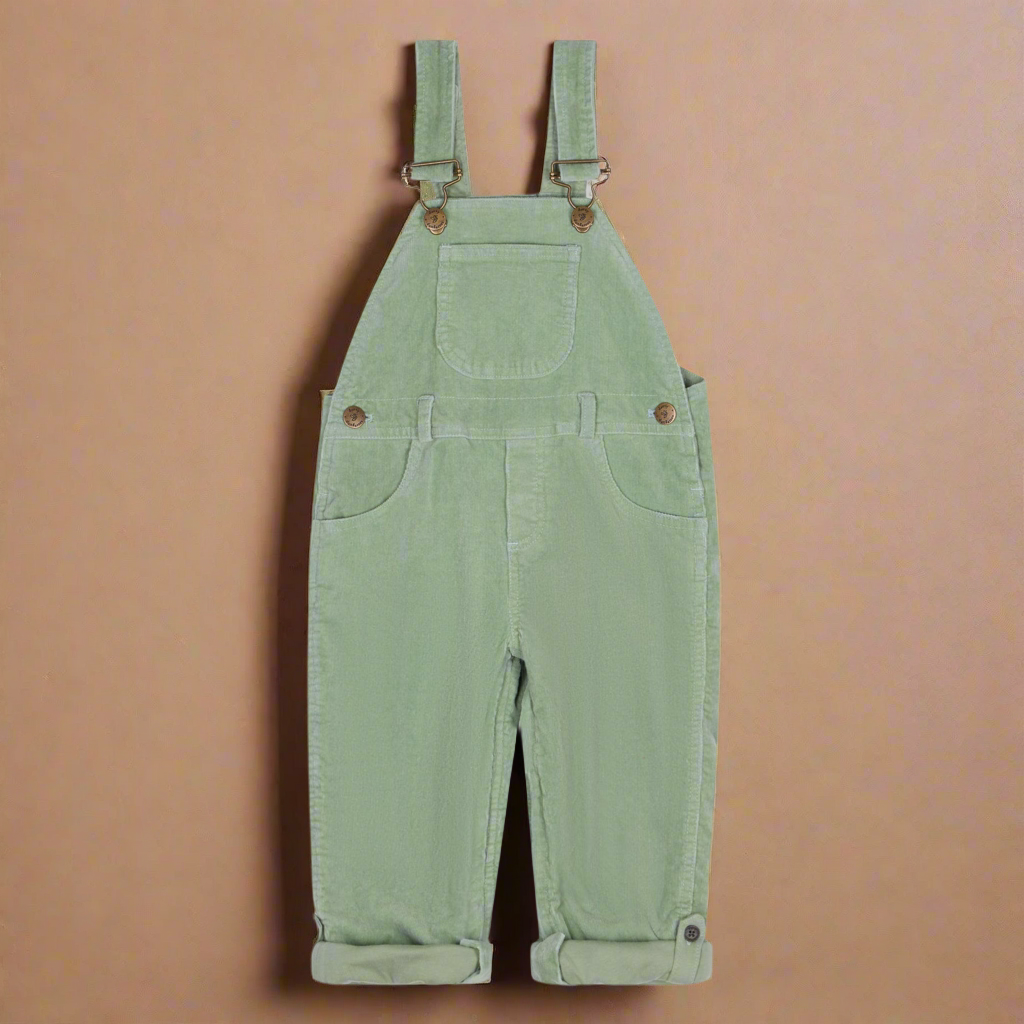 Sage green corduroy dungarees with two side pockets and one central ocket on the chest and brass buttons