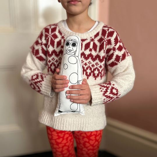 Child holding screen printed doll in both hands