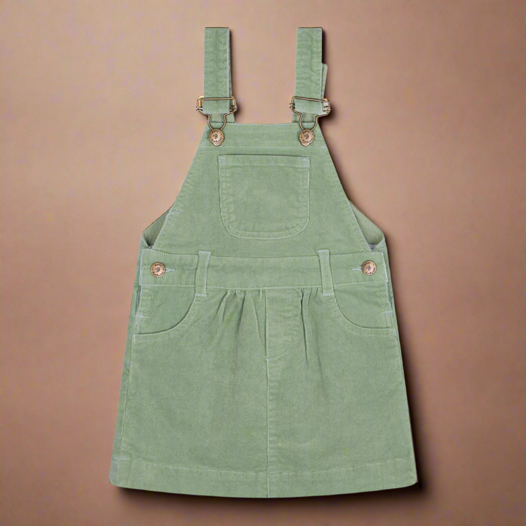 Sage green coloured corduroy dress with two pockets on the side and one central chest pocket with brass buttons