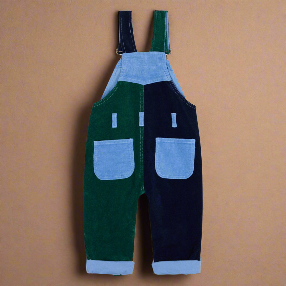 Patchwork dungarees facing backwards showing two pockets on the rear. Looking at it the left side is dark green, the right side is dark blue and the pockets are light blue
