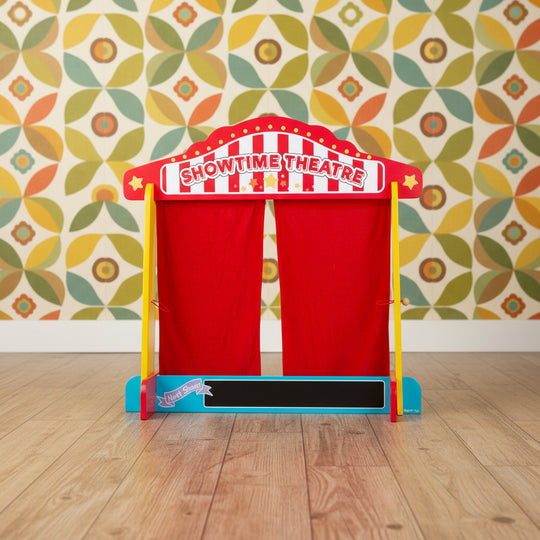 A wooden puppet theatre with red silk effect curtains and a chalkboard, designed for children.
