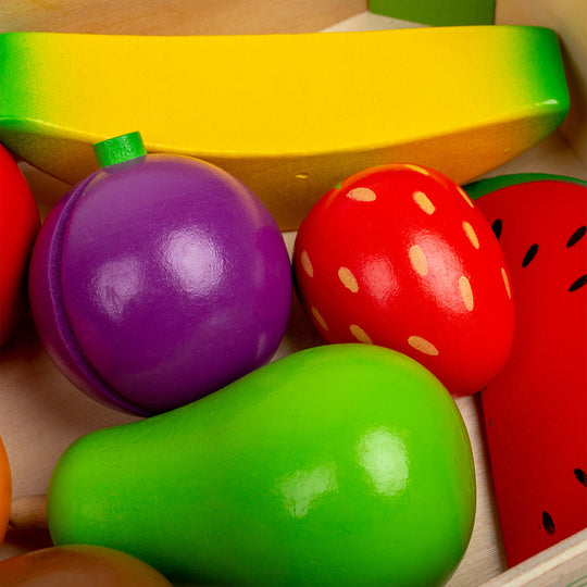 Colorful toy fruits and vegetables on a wooden surface