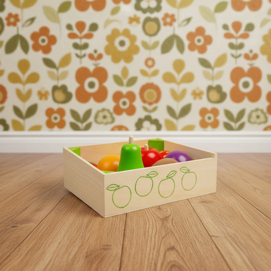 Colorful toy fruits in a wooden box with fruit illustrations on a white background