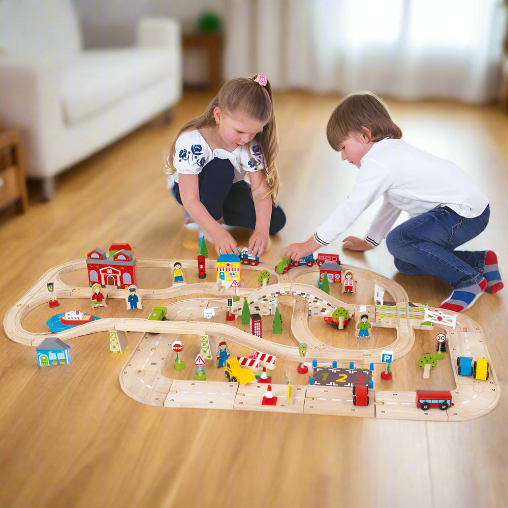 Two children playing with train set on the floor