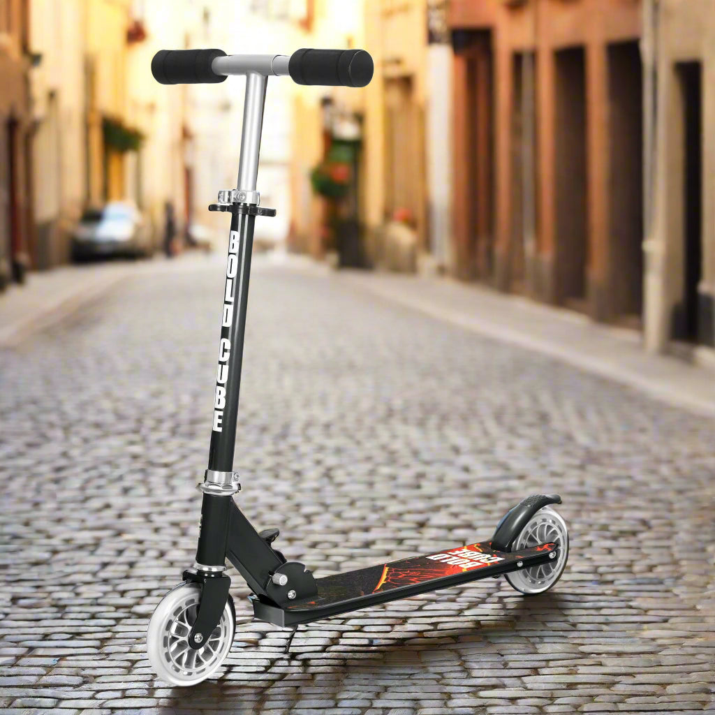 Black scooter with logo 'Bold Cube' on its vertical bar and a red design on the tread of the scooter, with a cobbled street in the background