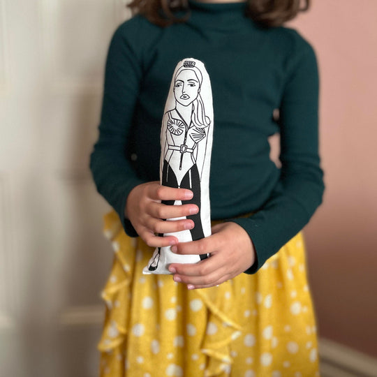 A child holding the screen printed doll cushion of Madonna