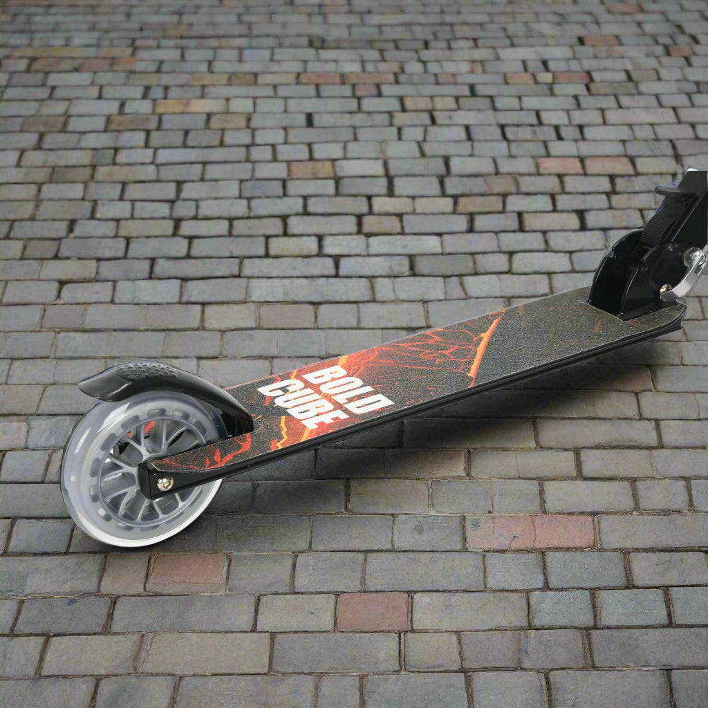 Close-up of red and orange design on the tread of the scooter, resembling a volcano and with the brand name 'Bold Cube' on a cobbled paving background