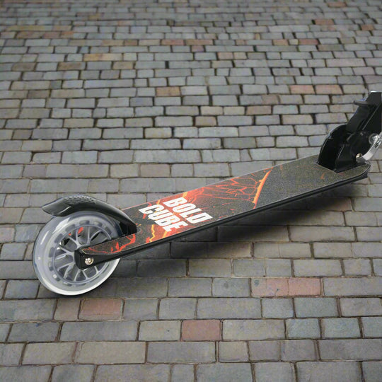 Close-up of red and orange design on the tread of the scooter, resembling a volcano and with the brand name 'Bold Cube' on a cobbled paving background