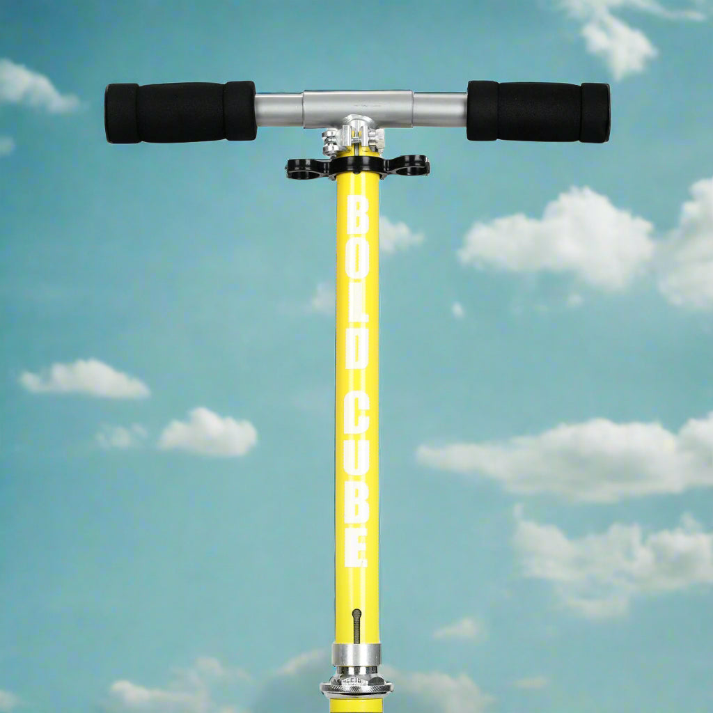 Close up of handlebars showing padded foam black handles and yellow vertical bar with Bold Cube written on it