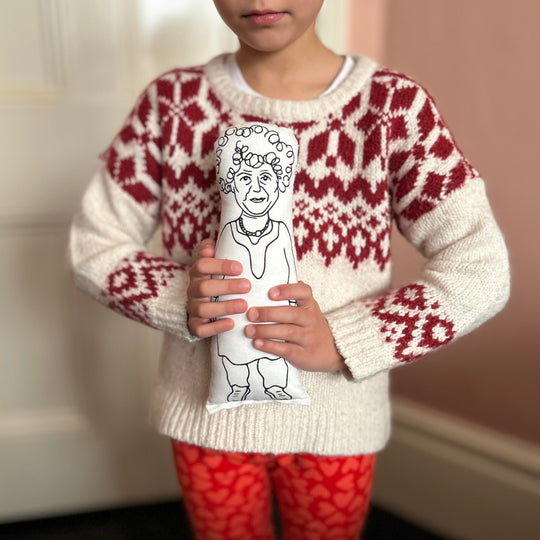 A child holding the screen printed doll cushion of actor Miriam Margolyes