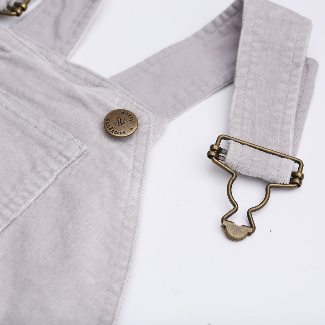 Close up of brass button with bee logo and 'Dotty Dungarees' written on it