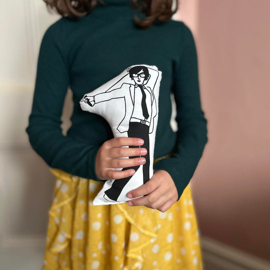 A child holding screen printed doll cushion of Jarvis Cocker