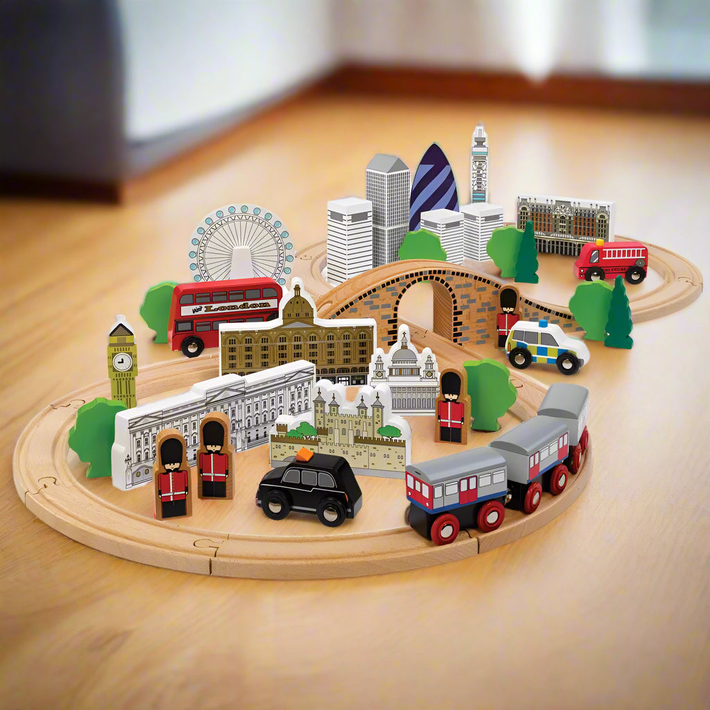 Wooden train set depicting famous London landmarks, with tracks arranged in a figure of eight layout, including a train, cars, trees, and buildings such as the London Eye and Buckingham Palace.