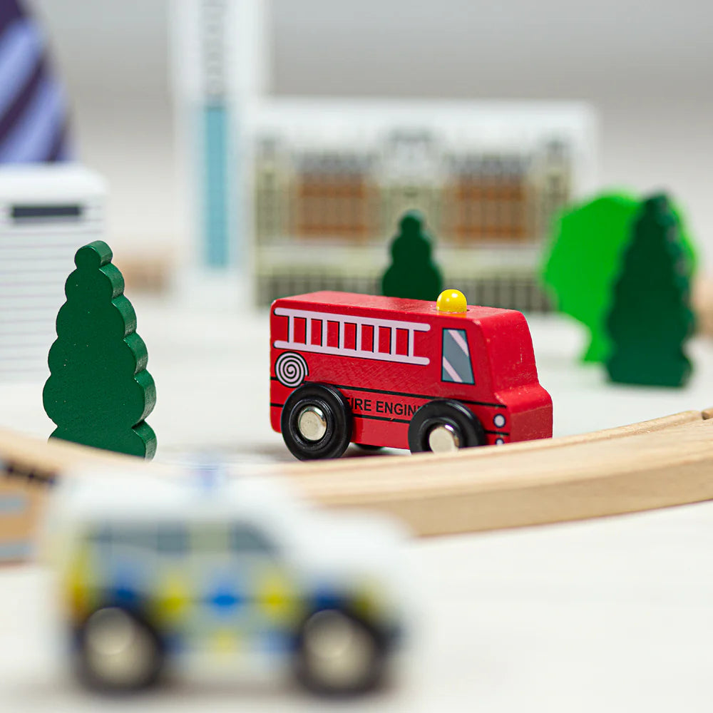 Close up of the toy fire engine, showing the painted ladder and hose on the side of the engine with a little yellow light on the top