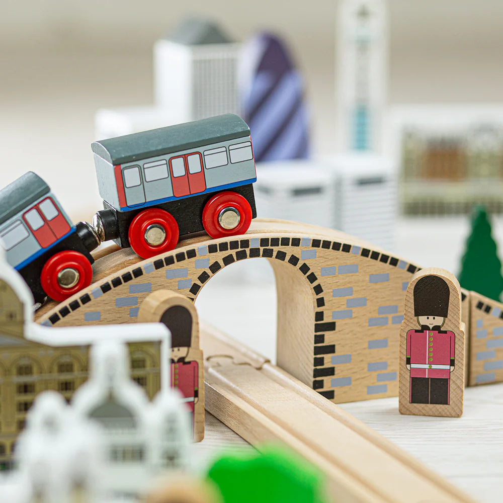 Close up of a train going over a bridge with wooden London guards in traditional dress
