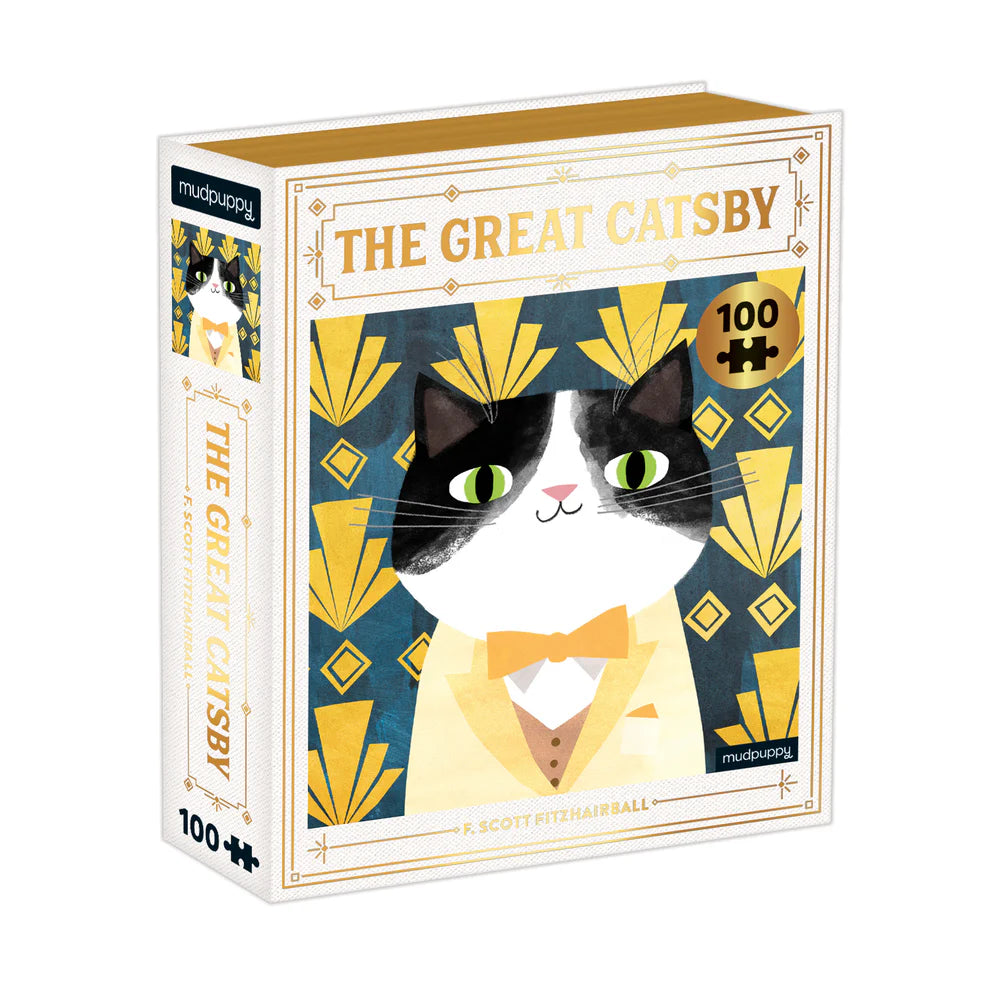 A 100-piece puzzle box featuring a stylized cat portrait with a bow tie, with gold foil embellishments and a book-style design with magnetic closure.