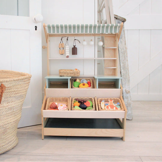 Wooden toy shelf with colorful toys and baskets in a room setting.