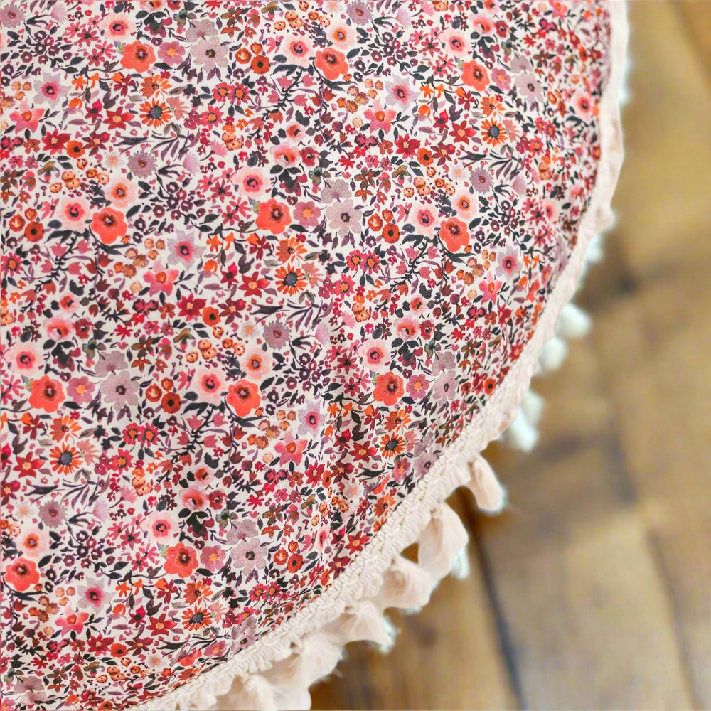 Close up of floor suchion showing floral fabric in detail with red and pink flowers