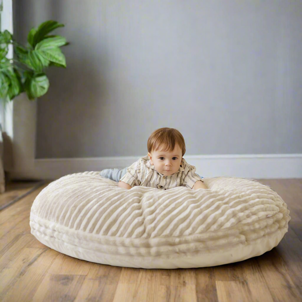 Young child sitting on corduroy floor cushion