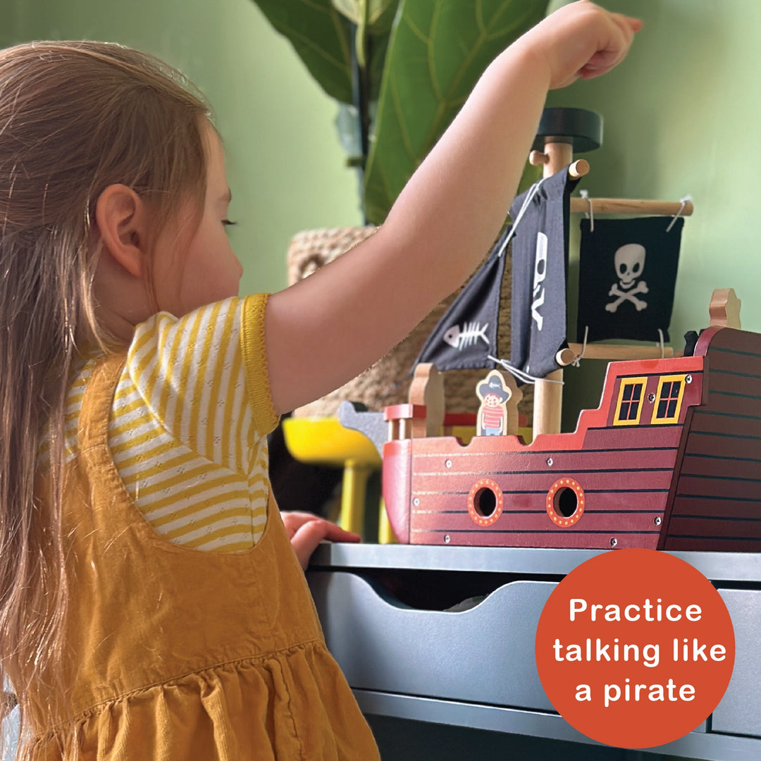 Child playing with a toy pirate ship indoors