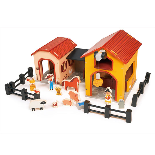 Toy farm set with barns, animals, and figures on a white background