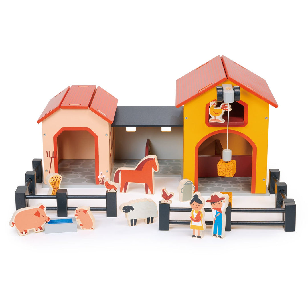 Toy farm set with barn, animals, and figures on a white background