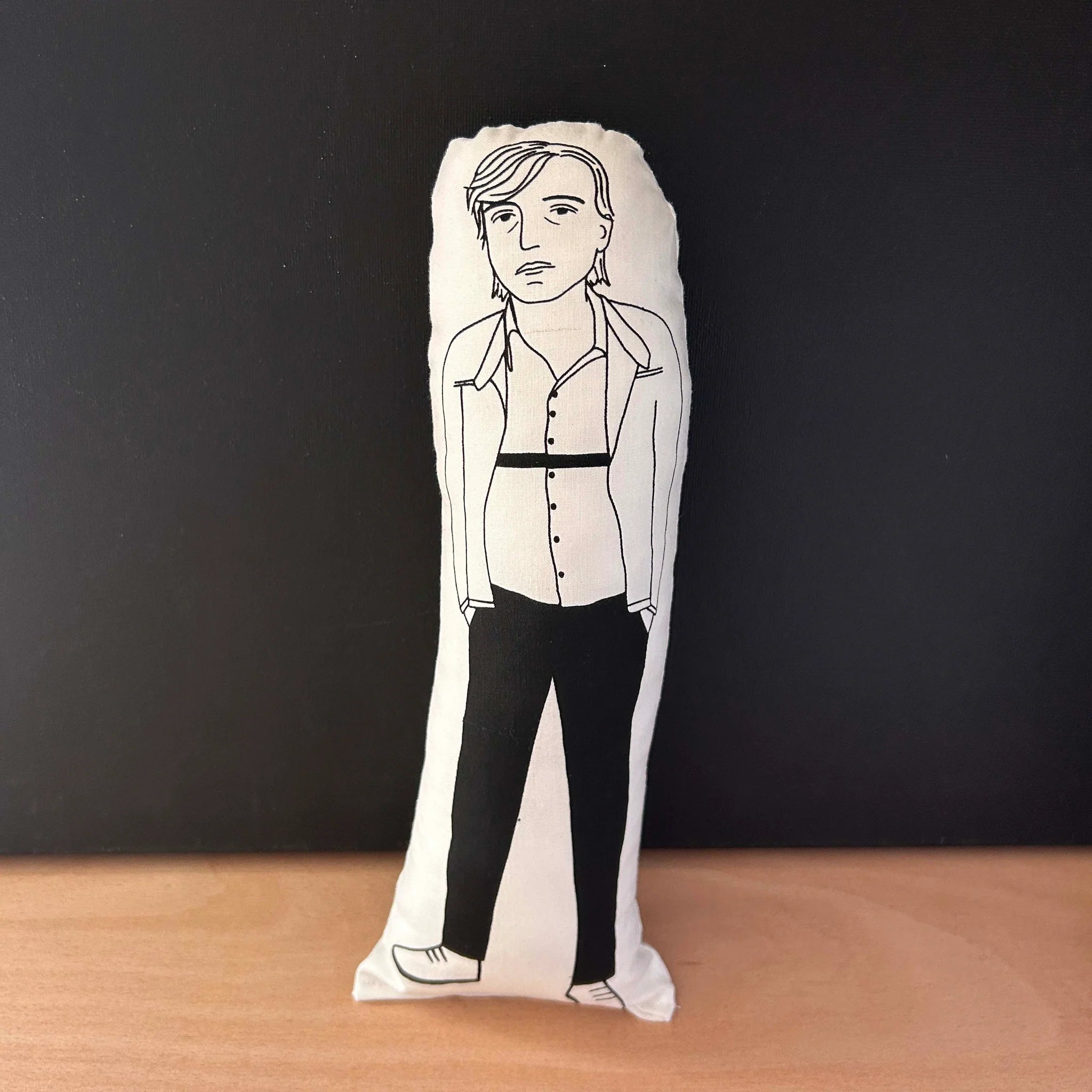Screen printed doll cushion with white fabric and black illustration depicting The Fall frontman Mark E Smith with his hands in his pockets