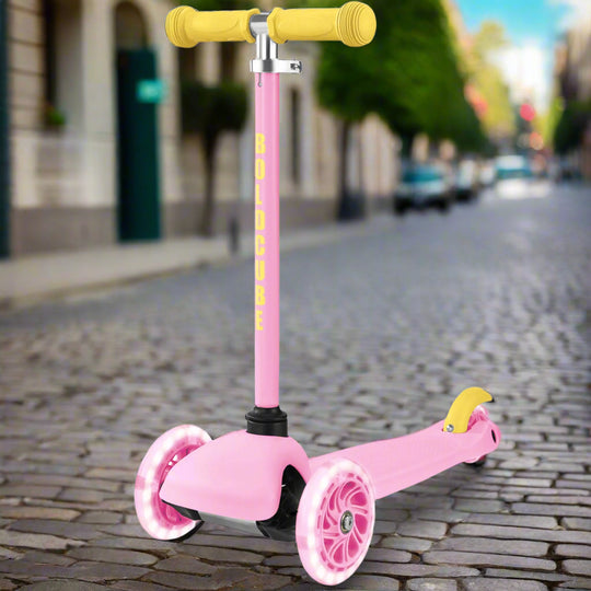 Pink scooter with yellow handlebar and wheels on a city street
