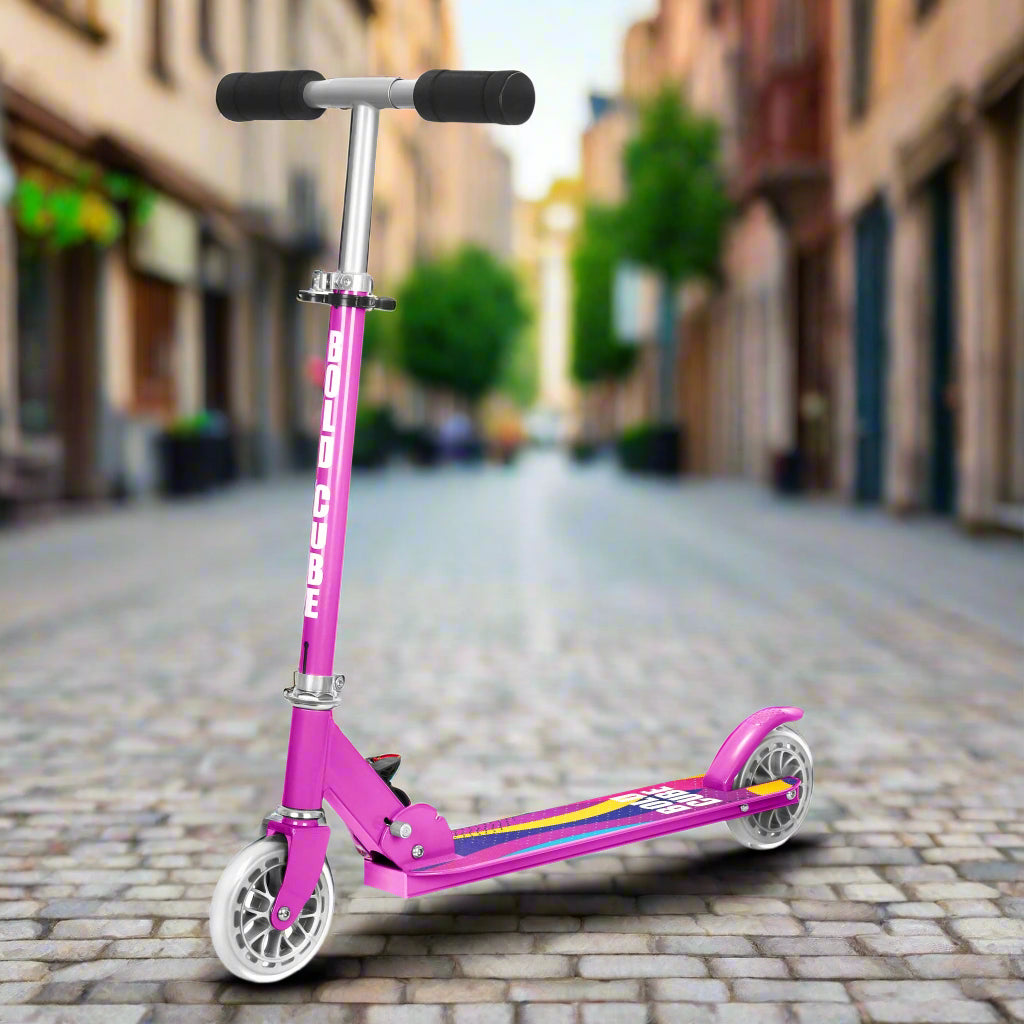 Purple scooter with blacl foam handles and a rainbow design on the tread on a cobbled city street