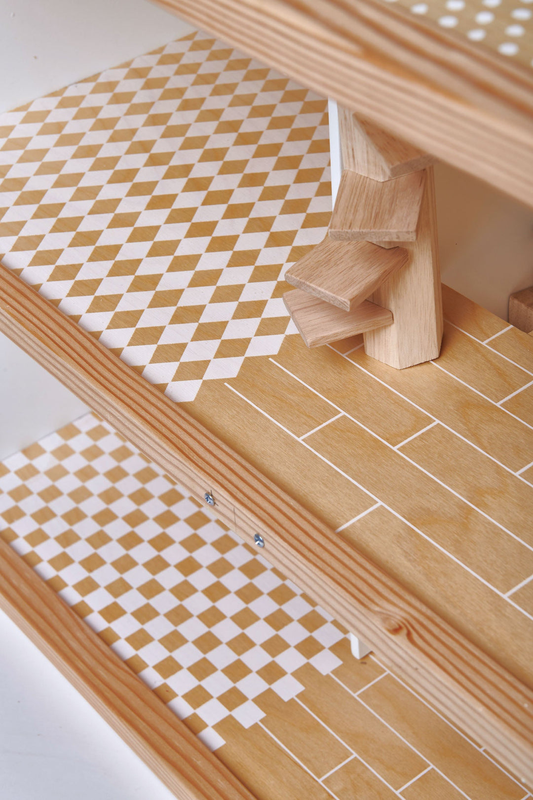 Wooden step stool with checkered mat on a tiled floor