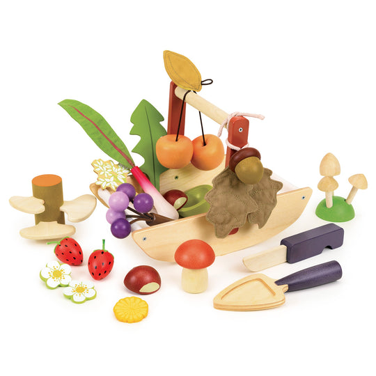 Wooden toy set with fruits, vegetables, and tools in a wooden gardening trug on a white background