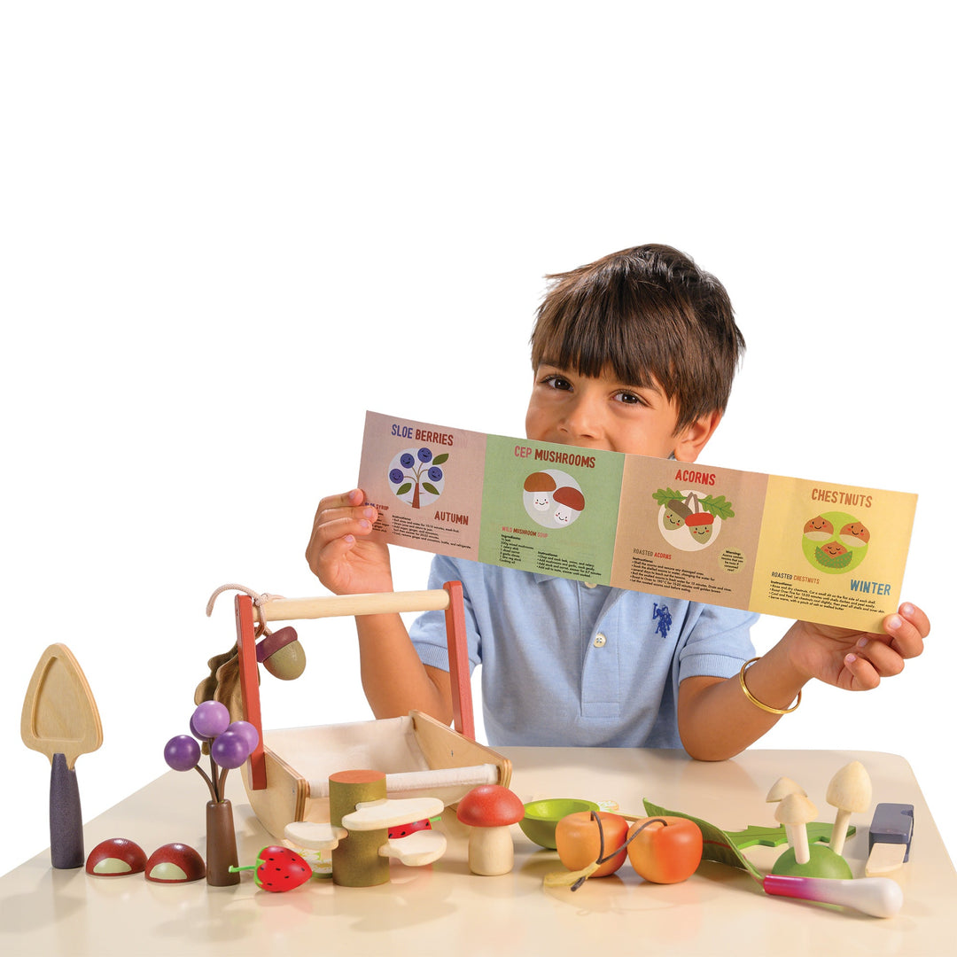 Child holding educational cards about vegetables with a wooden toy set on a white background