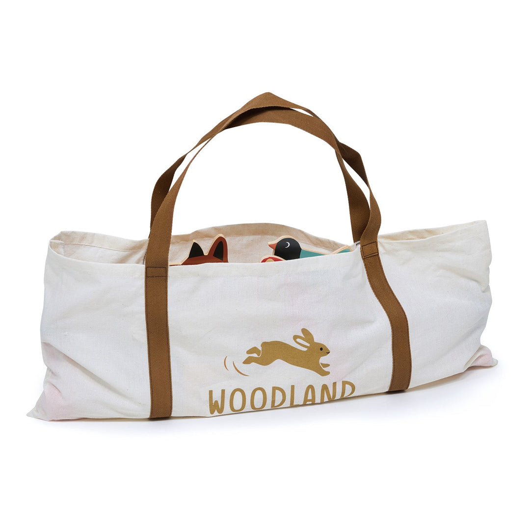 Canvas tote bag with brown handles featuring a rabbit illustration and 'Woodland' text on a white background.